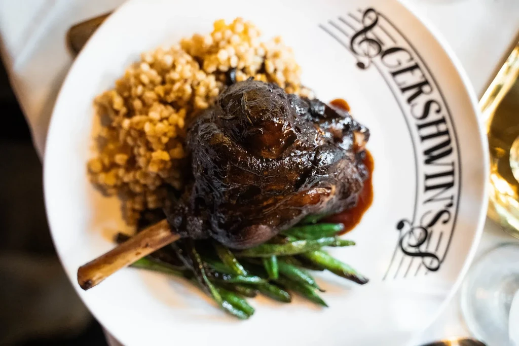 Braised meat shank, green beans, and pilaf on a Gershwin's plate.