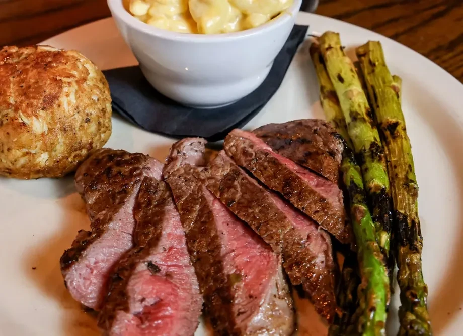 Medium-rare steak with grilled asparagus, crab cake, and creamy mac and cheese.