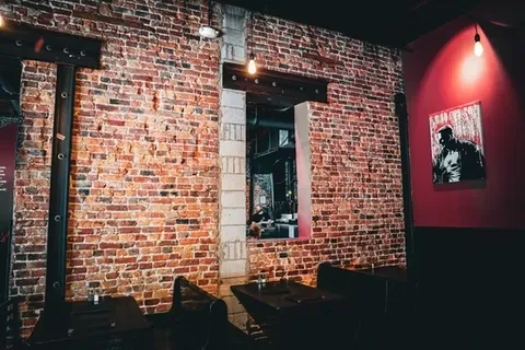 Exposed brick wall in a dimly lit industrial-rustic restaurant interior.