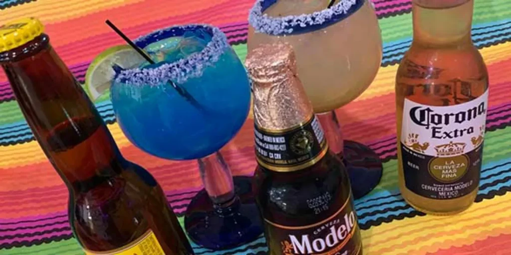 Beers and margaritas on a colorful striped Mexican blanket.