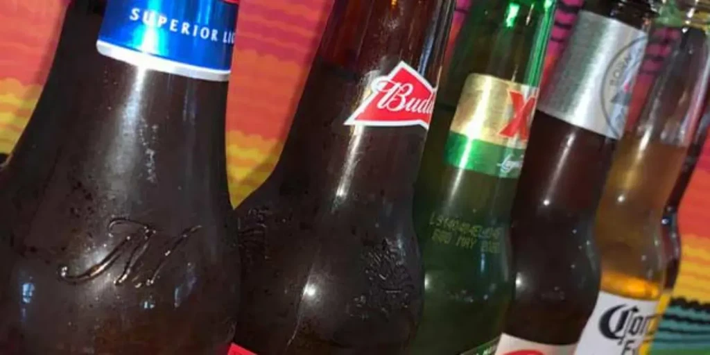Five cold beer bottles in a diagonal line on a colorful serape.