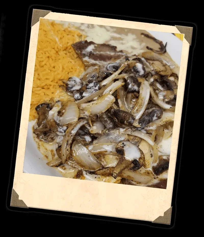 Creamy sautéed onions, meat, orange rice, and beans on plate.