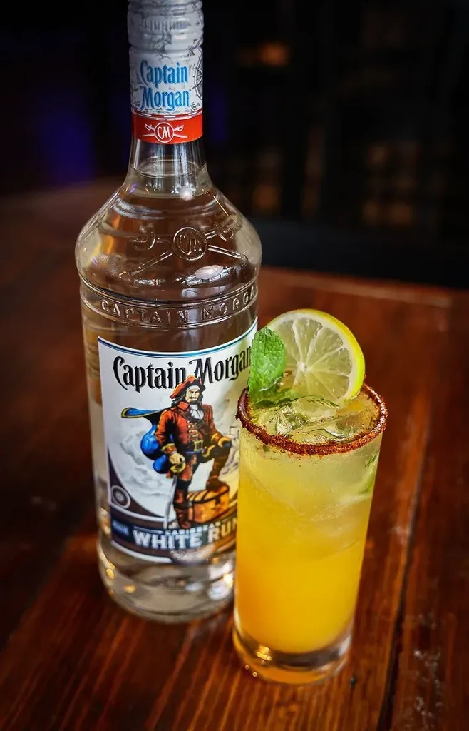 Captain Morgan White Rum bottle and a spiced-rim cocktail with lime, mint.
