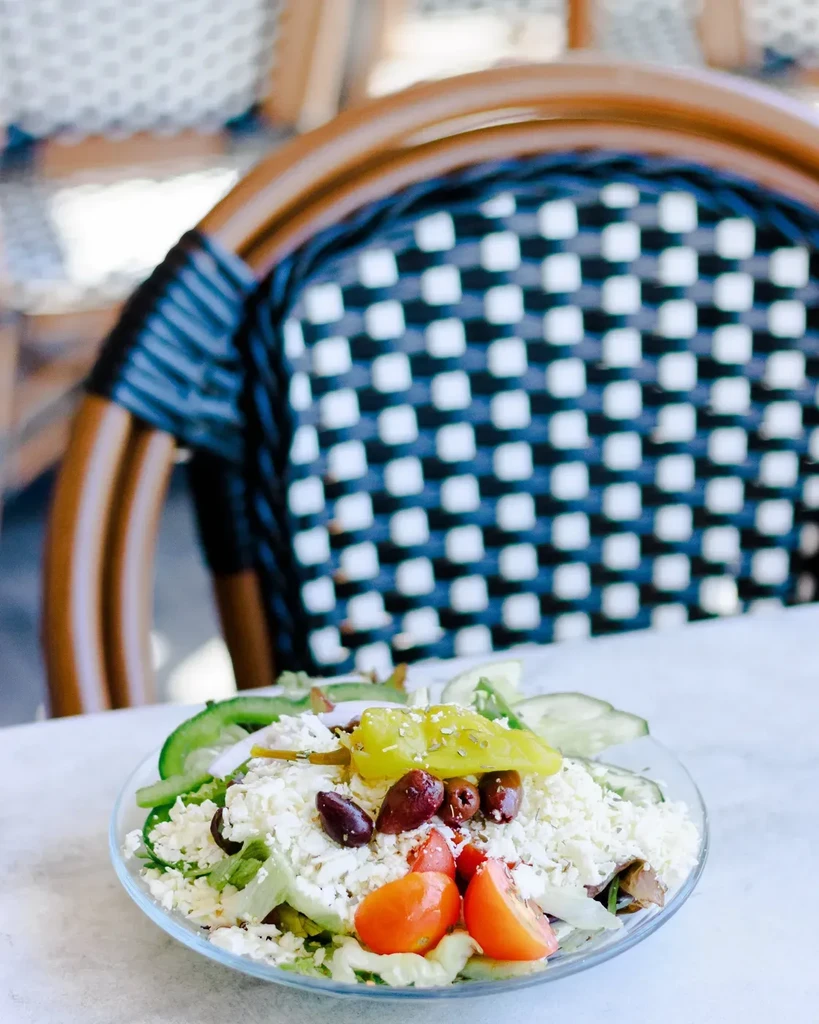Fresh Greek salad with feta, olives, and tomatoes in a glass bowl.