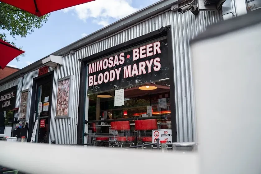 Corrugated metal restaurant exterior advertises mimosas, beer, and bloody marys.