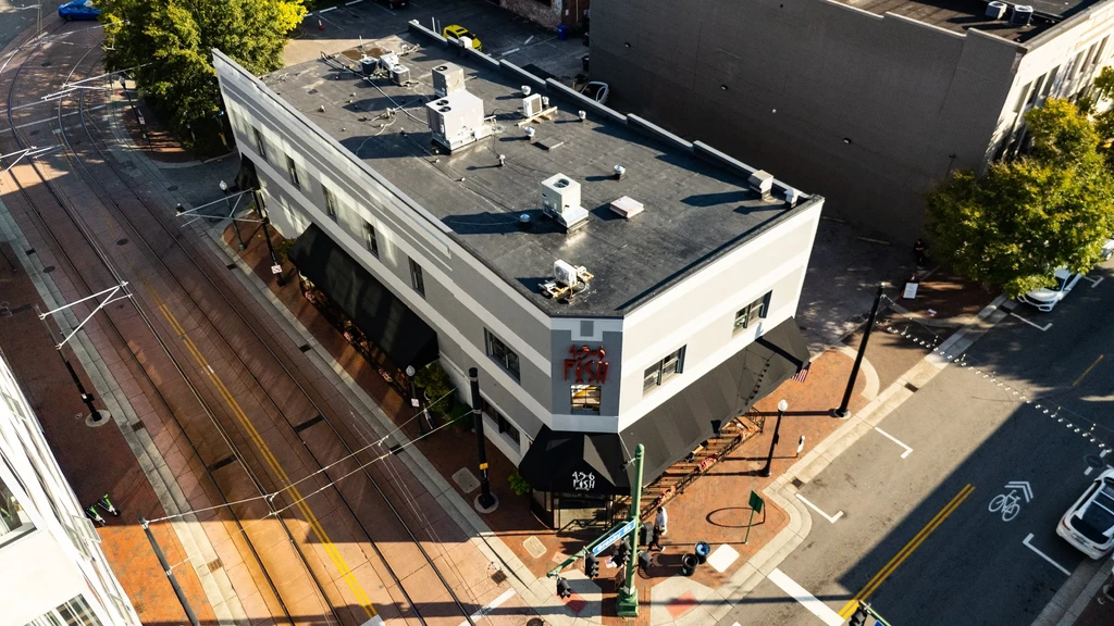 Aerial view of '426 FISH' building on a sunny urban street corner.