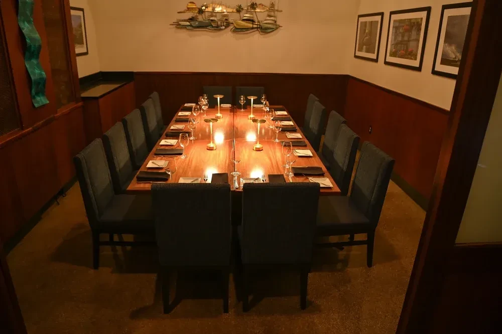 Elegant, empty private dining room with a long table set for dinner.