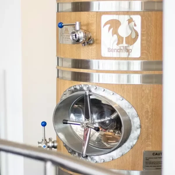 Large wooden fermentation tank with metal bands, hatch, and Benchtop label.