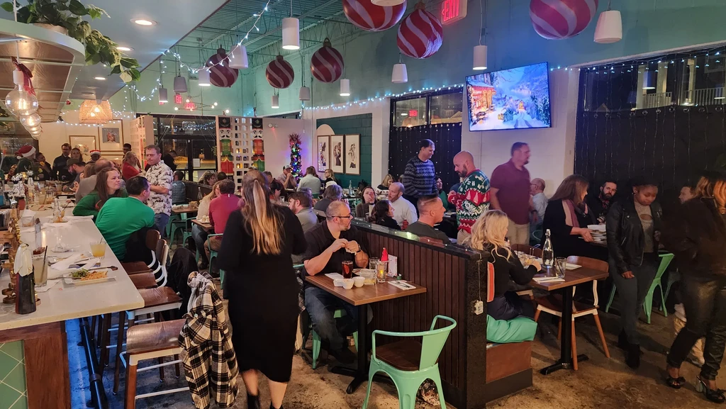 Lively, holiday-decorated restaurant interior filled with many patrons.
