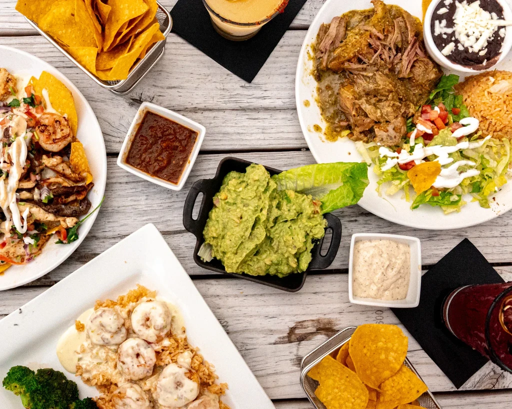 Top-down view of various colorful Mexican dishes, sides, and drinks.