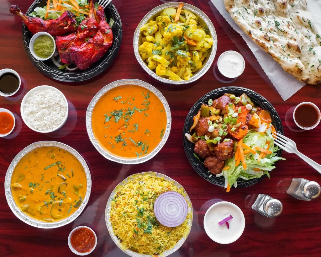 Overhead view of abundant Indian take-out dishes on a table.