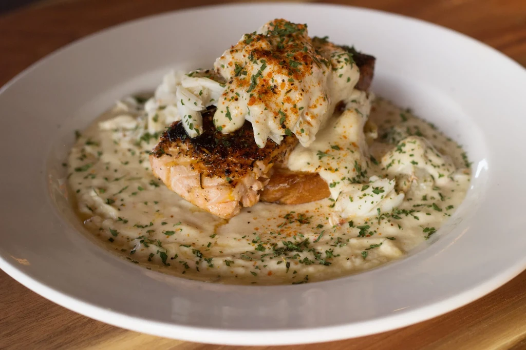 Seared salmon, creamy sauce with white meat, herbs, on mashed potatoes.