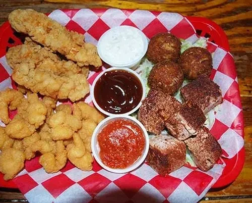 Platter of fried chicken, shrimp, hushpuppies, pork belly, and sauces.