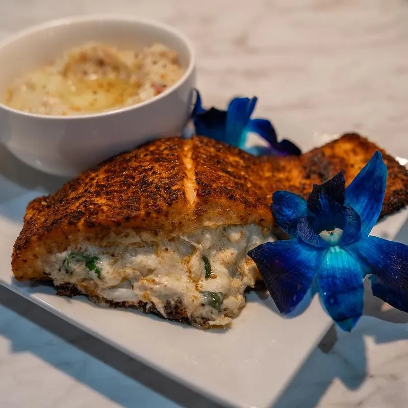 Crusted stuffed seafood with creamy filling, garnished with blue orchids.