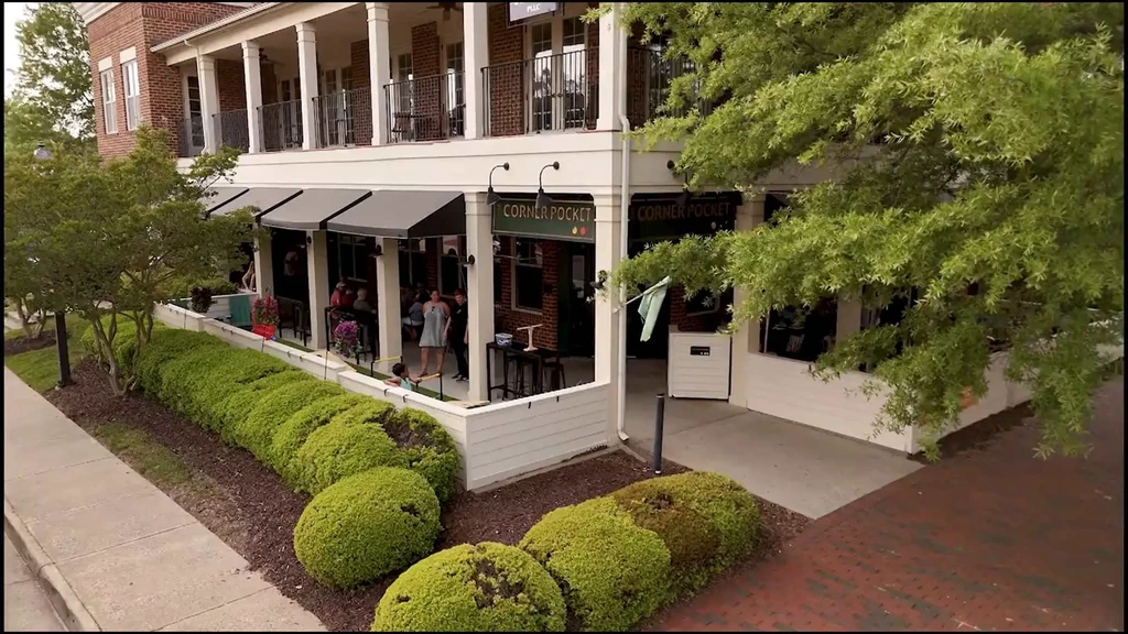 Corner Pocket restaurant's outdoor patio with diners and brick building.