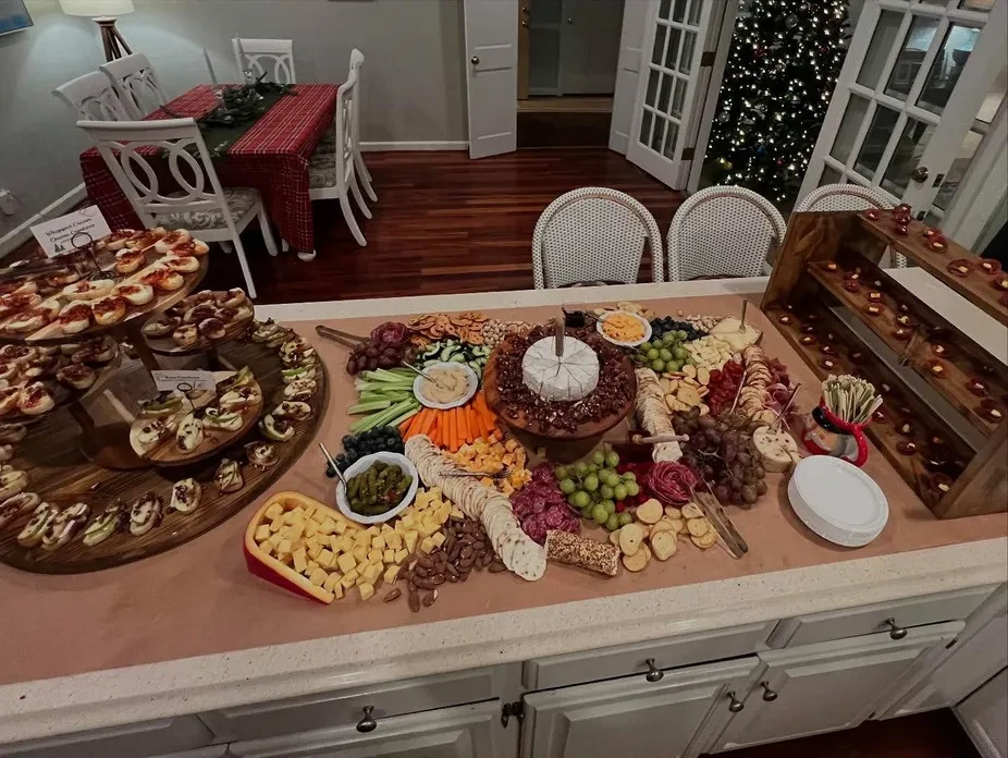 Lavish charcuterie board, tiered appetizers, and desserts at a holiday event.