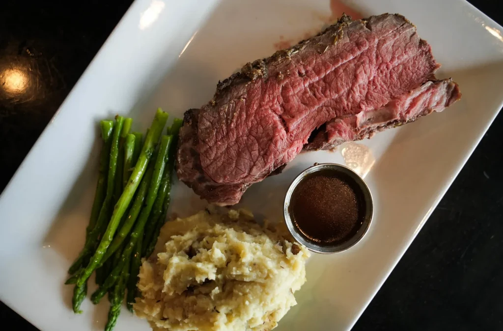 Medium-rare roast beef, green asparagus, mashed potatoes, and gravy.