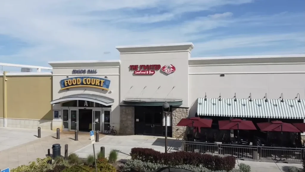 Commercial building exterior with Food Court, Twisted Crab, and outdoor dining.