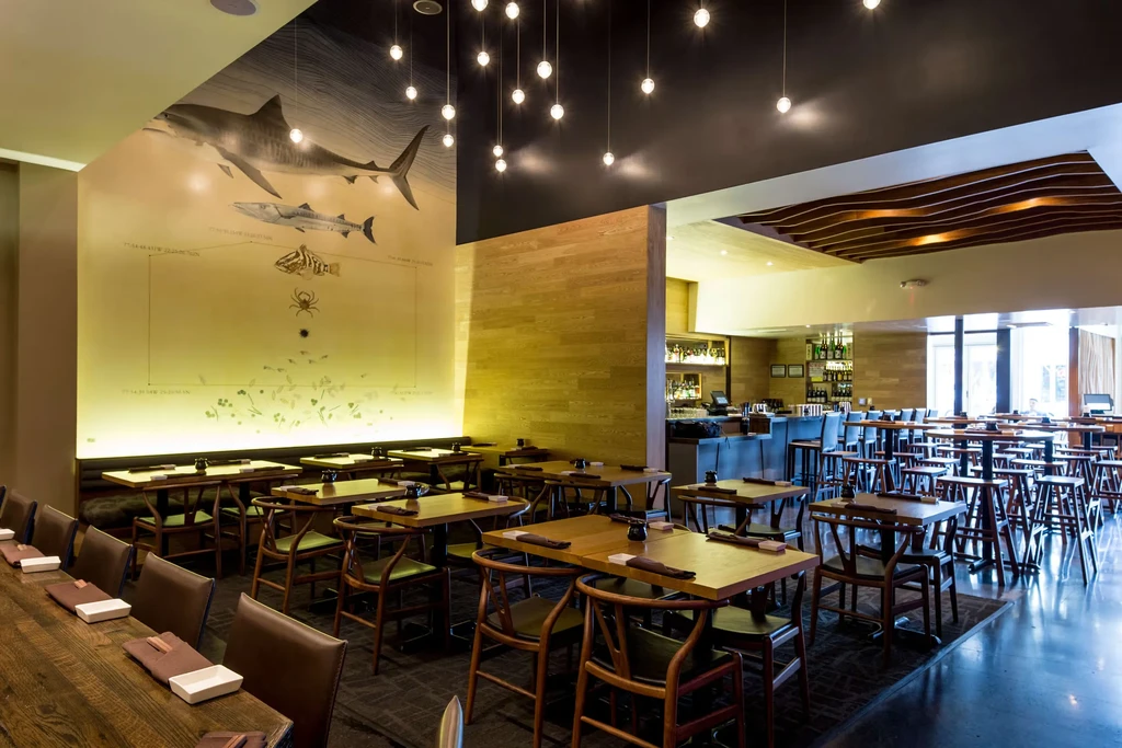 Stylish, empty restaurant interior with large marine mural and bar.