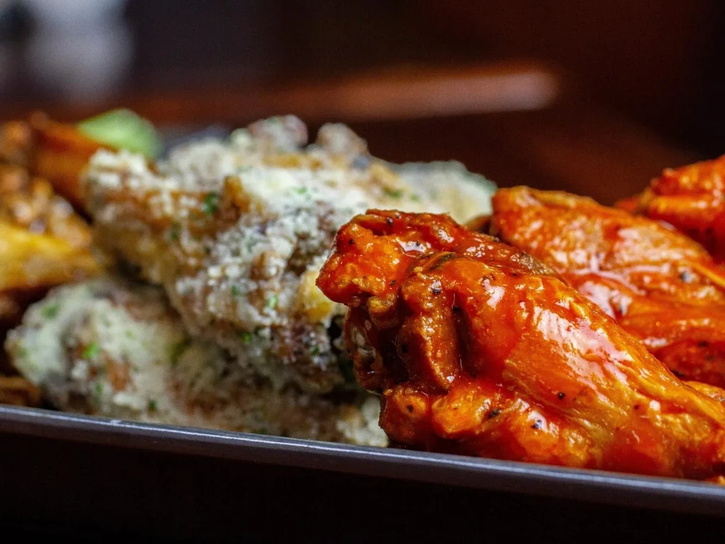 Plate of red buffalo and garlic parmesan chicken wings.