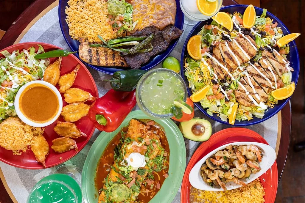 Overhead view of a diverse spread of Mexican food and beverages.