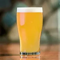 Close-up of a golden beer pint glass with foam.