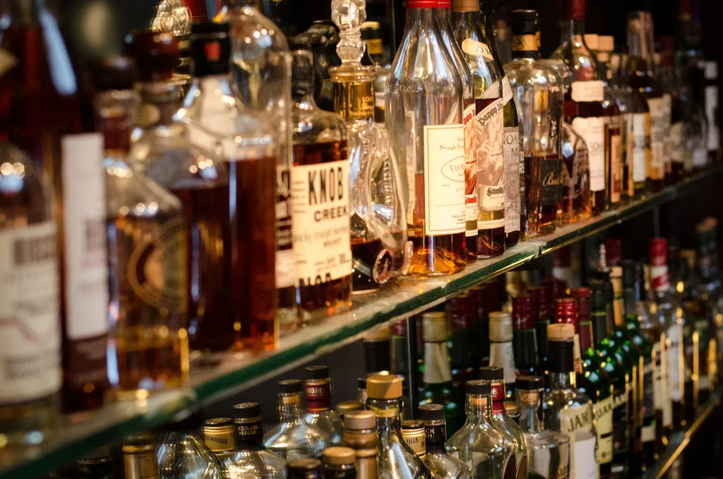 A well-stocked bar shelf with various whiskey and bourbon bottles.
