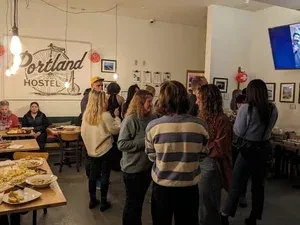 Casual, lively gathering of people conversing and eating at Portland Hostel.