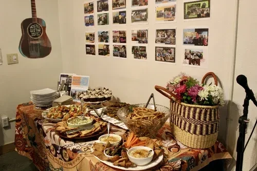 Vibrant buffet table with food, fresh flowers, and guitar decor.