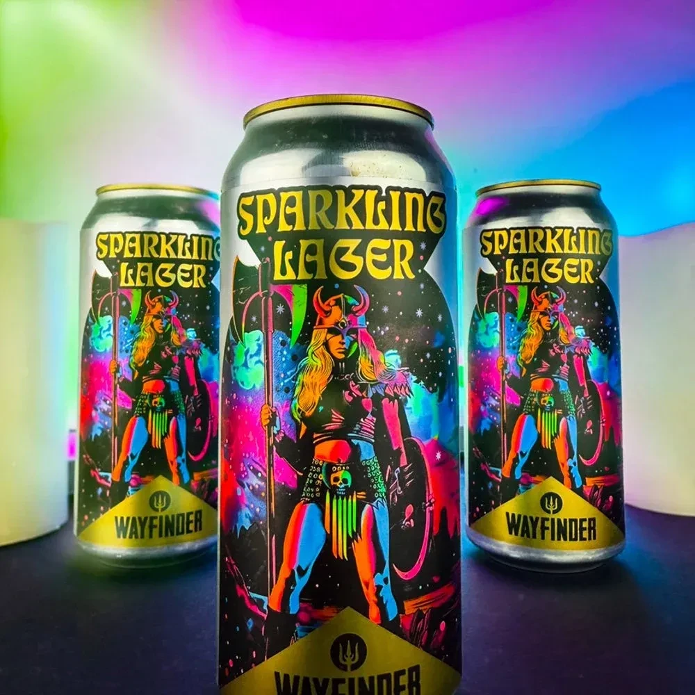 Three silver Wayfinder cans with 'Sparkling Lager' and warrior art.