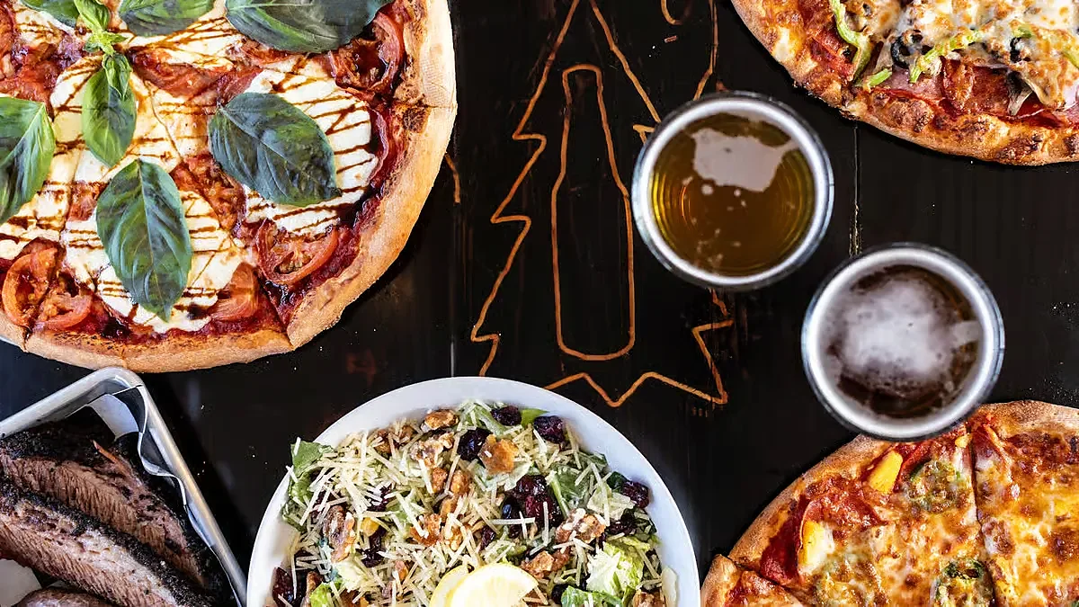 Two pizzas, Caesar salad, sliced brisket and two beers overhead