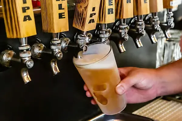 Beer being poured into pint glass at the tap wall