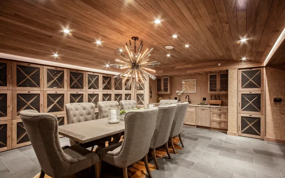 Warmly lit private dining room with a long table and wine cabinets.