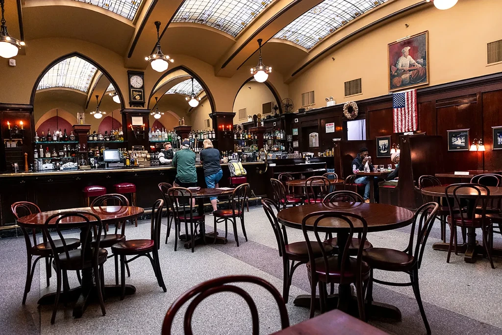 Spacious, elegant bar and restaurant with stained-glass ceiling and dark wood.