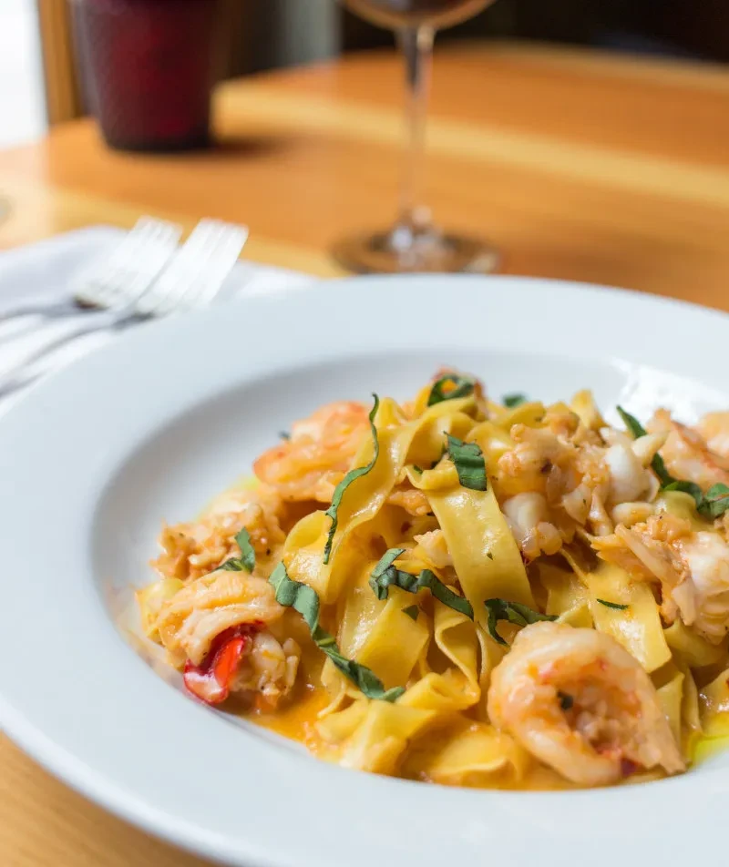 Creamy tagliatelle pasta with shrimp, lobster, and fresh basil.