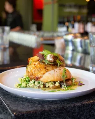 Crispy chicken, grain salad, herbs, and mushrooms in a restaurant.