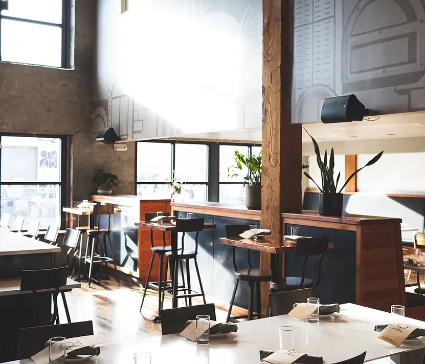 Bright, empty industrial restaurant interior with diverse seating.