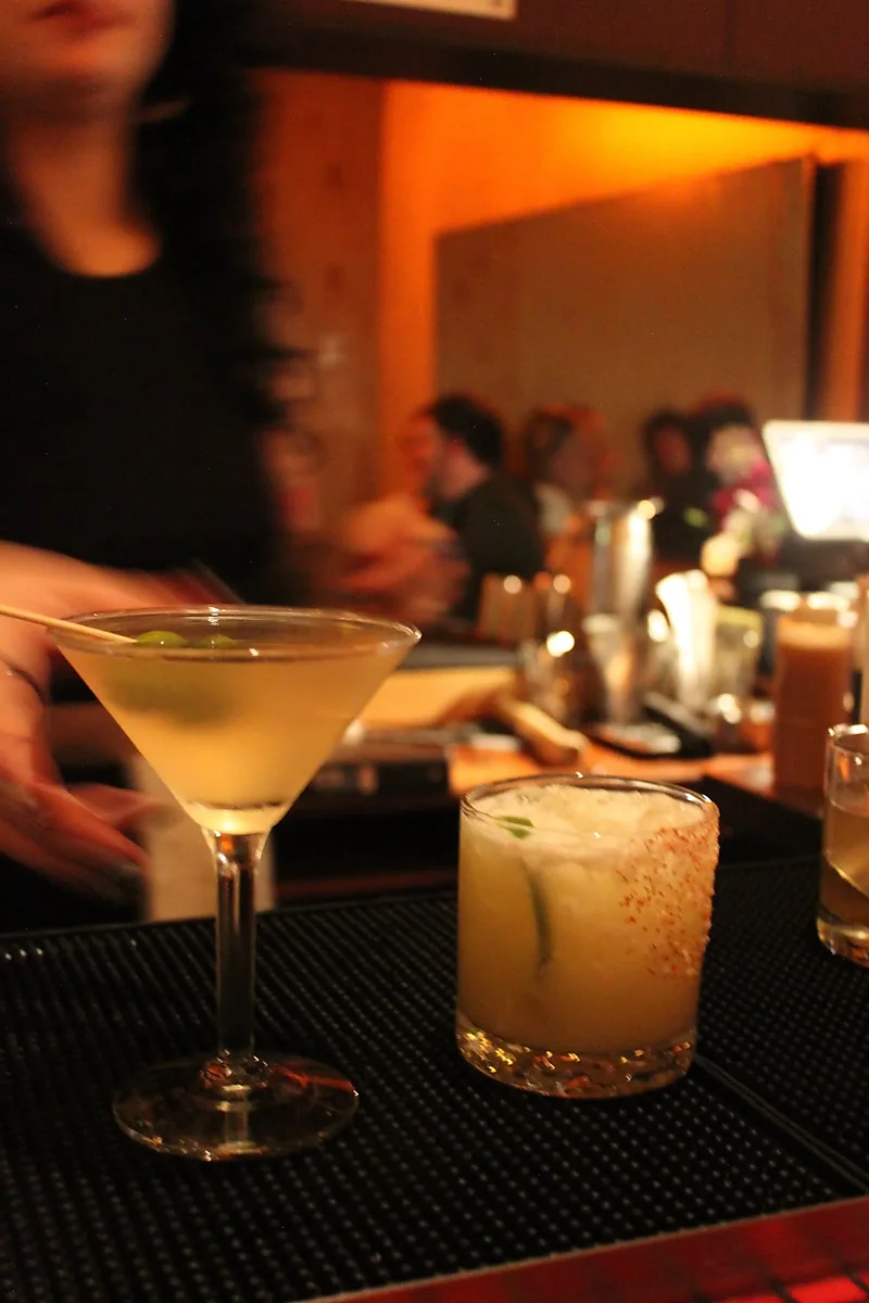 Martini and margarita served on bar mat in dim lounge