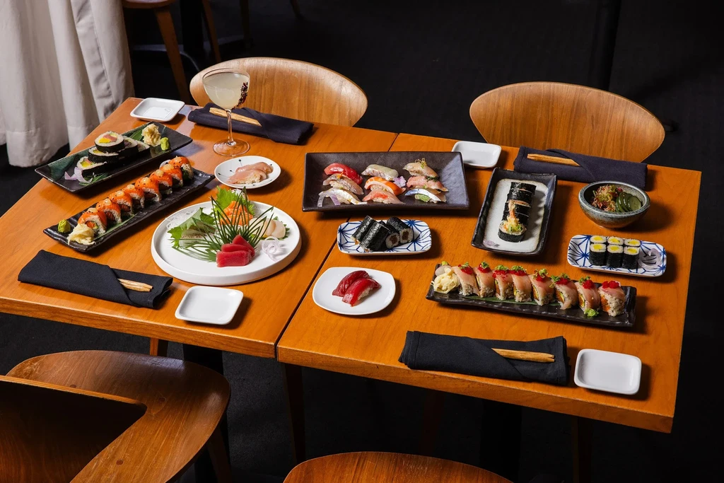 Meticulously arranged sushi and sashimi spread on a wooden table.