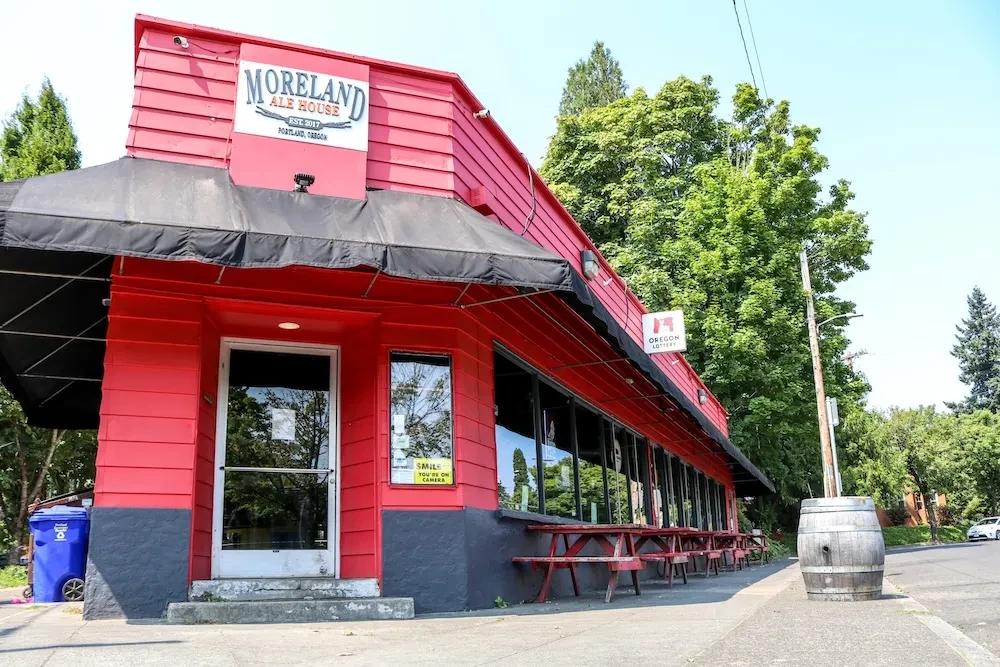 Red Moreland Ale House building with outdoor seating on a clear day.