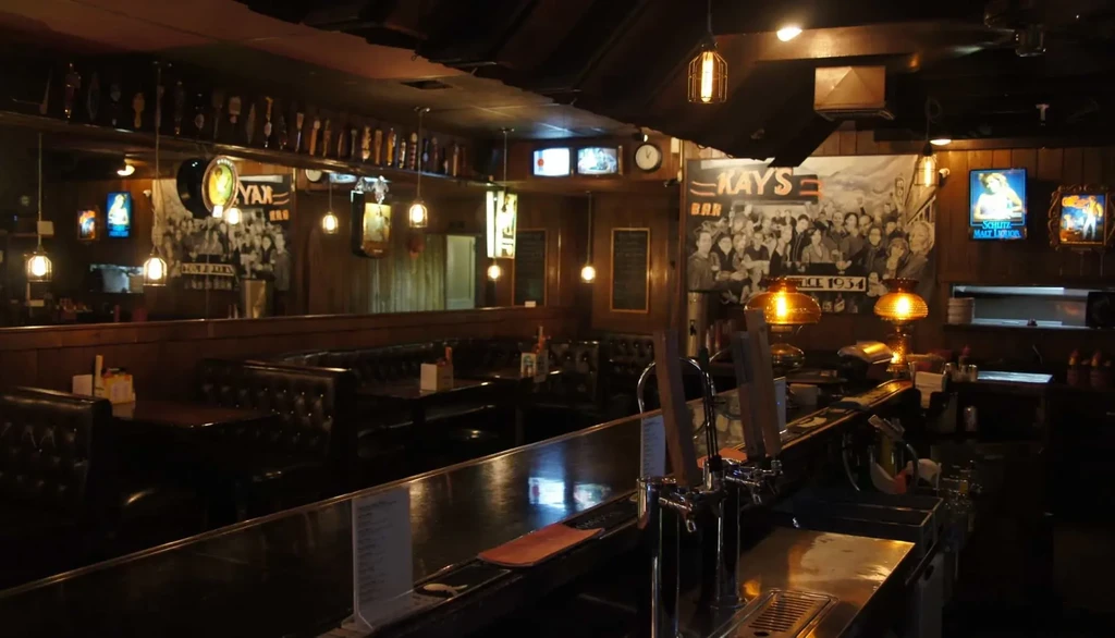 Kay's Bar interior: dimly lit, dark wood, leather booths, prominent bar.
