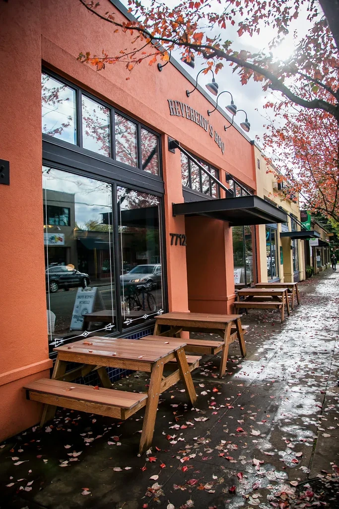 Reverend's BBQ restaurant exterior with wet autumn leaves and outdoor seating.
