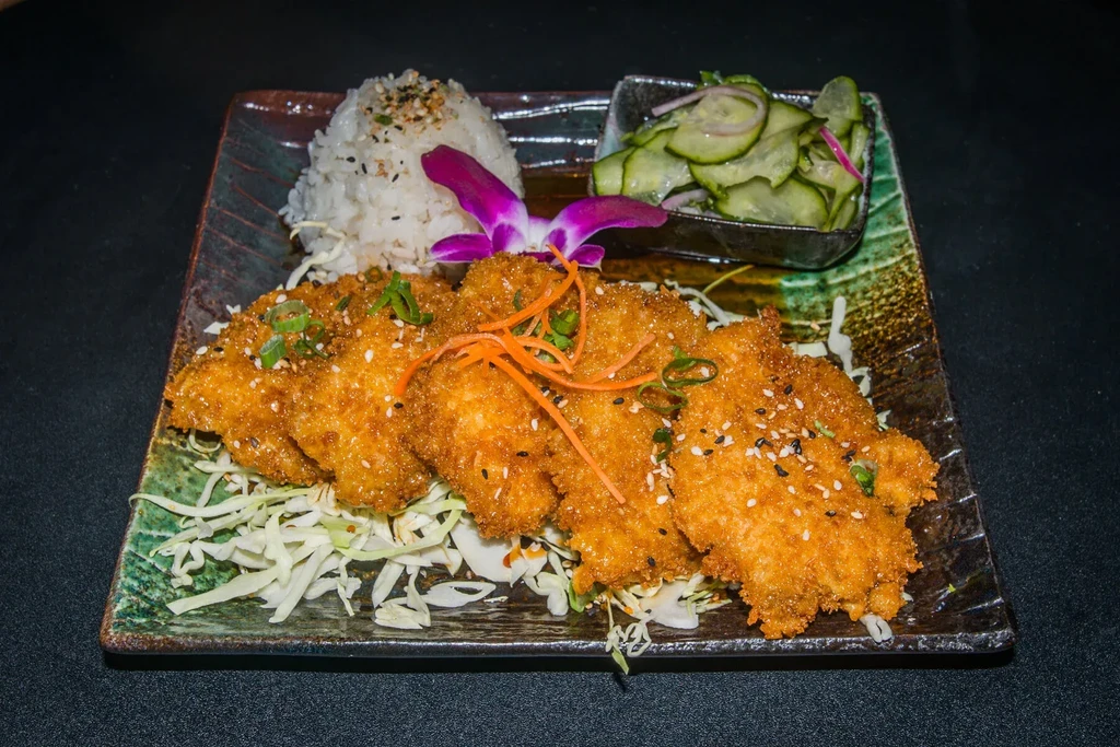 Japanese katsu, white rice, cucumber salad, and purple orchid.