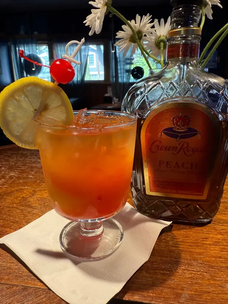 Orange gradient cocktail, lemon and cherry, with Crown Royal Peach.