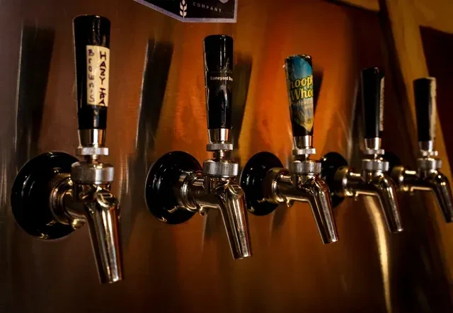 Five brass beer tap handles with 'Hazy IPA' and 'Boneyard' labels.