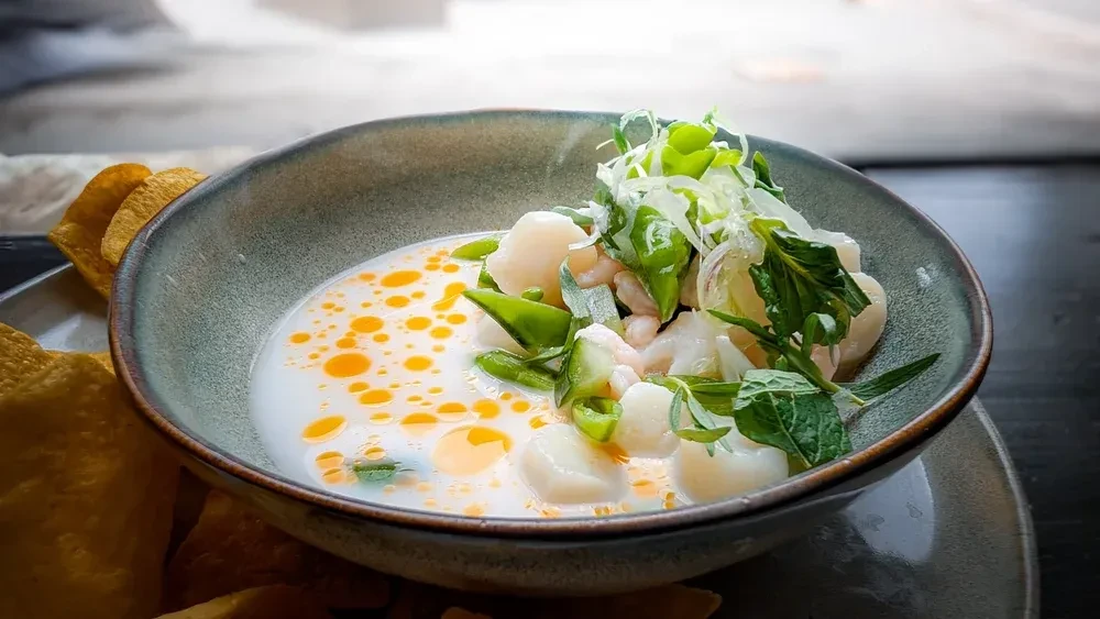 Creamy seafood soup with green beans, herbs, and tortilla chips.