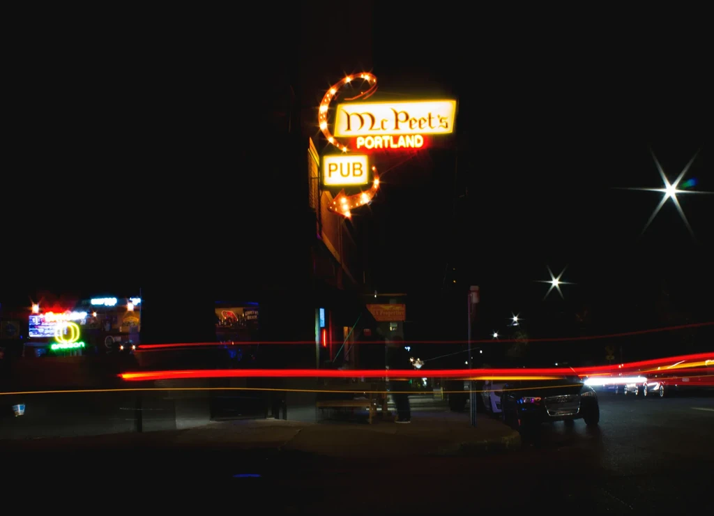 McPeet's Pub neon sign in Portland, with streaking vehicle light trails.