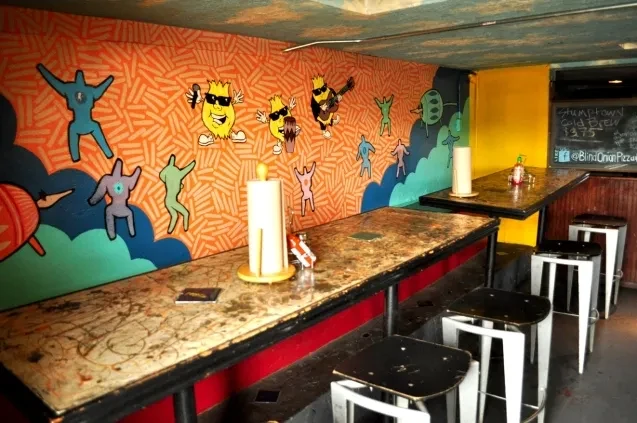 Colorful restaurant interior with potato characters on a wall mural.