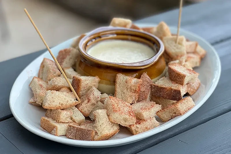 Creamy dip pot with paprika-dusted bread cubes and skewers.