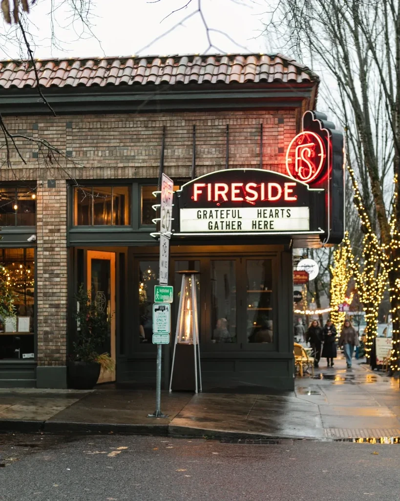 FIRESIDE restaurant exterior, red neon sign, wet street, string lights.